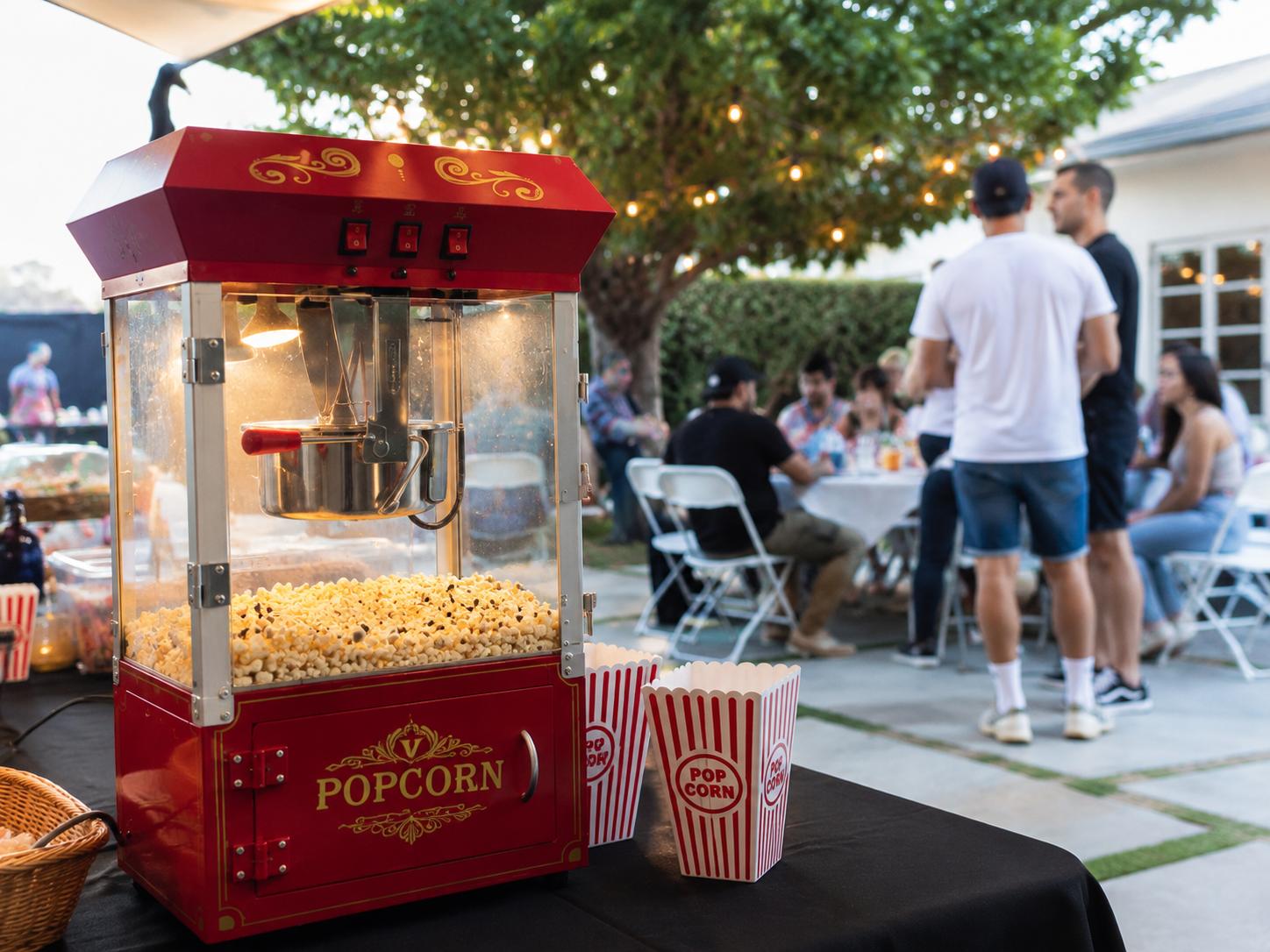 Vintage-style red and white popcorn machine cart with fresh popcorn